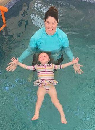 Kim in water with child