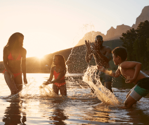 family playing in water at lake