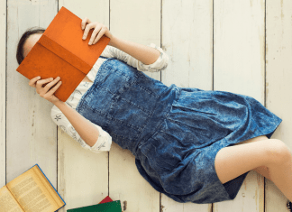 Woman laying on floor reading a book
