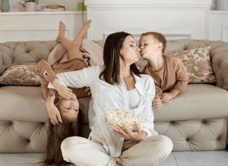 mom and children eating popcorn on the couch