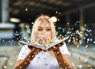 Woman blowing confetti on book