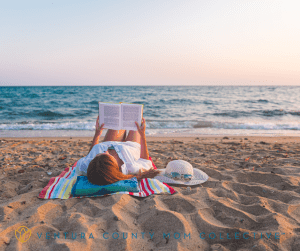 Woman reading a book at the beach