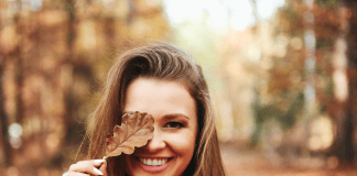 Smiling Woman Covering Her Eye with a Leaf